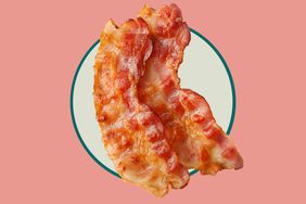 Two strips of cooked bacon in a peach and green background. 