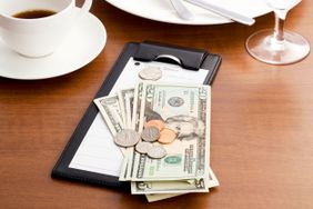 A cash and coins tip on a restaurant table