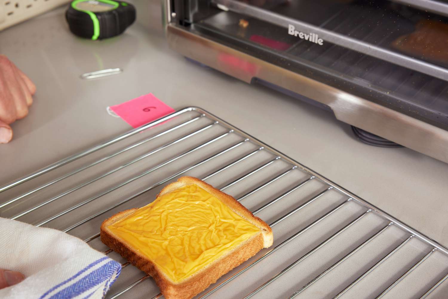 A piece of cheese toast on a tray next to the Breville Smart Oven Air Fryer