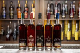 Bottles of Buffalo Trace Sazerac 18-Year-Old Straight Rye Whiskey, Thomas H. Handy Rye Straight Rye Whiskey, George T. Stagg Straight Bourbon Whiskey, William Larue Weller Straight Wheated Bourbon, and Eagle Rare 17-Year-Old Straight Bourbon Whiskey on a bar. 