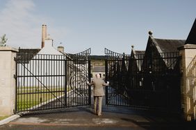 A man opening at gate at Brora Distillery.